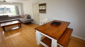 Ein Wohnzimmer mit einem Holztisch, einer Couch und einem Sessel.