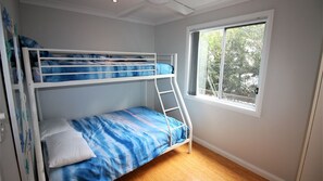 A bunk bed room with a window and a wooden floor. - Hop Hop House is pet friendly near the beach (Bendalong)