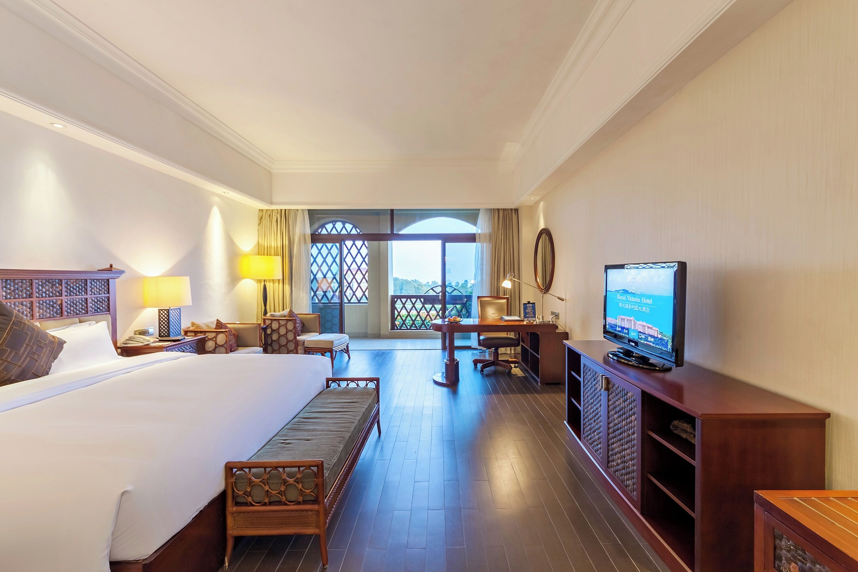 Habitación de hotel con cama, escritorio, televisión y vistas por la ventana.