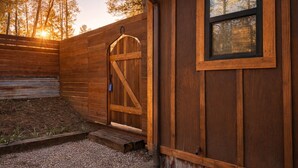A wooden building with a large barn door and a small window. - Rustline Haus - Cabin w/ Hot Tub, Walk to Village (Ruidoso)