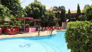 Een buitenzwembad, ligstoelen bij het zwembad