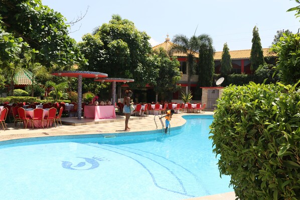 Una piscina al aire libre, sillones reclinables de piscina