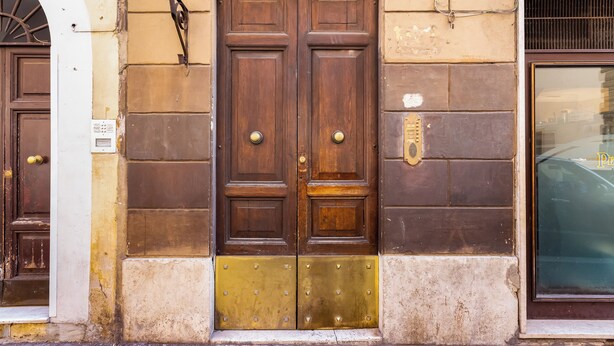 A double wooden door with brass knockers and a brass threshold. - PIAZZA DI SPAGNA FABULOUS AND COZY APARTMENT (Roma)