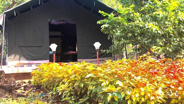 A small, dark-colored building with a simple, open entrance. - Nivant Agro Experience (Vada)