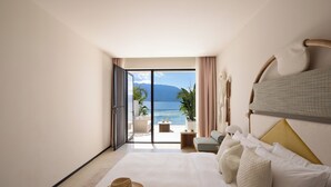 Habitación de hotel con cama, un sombrero y vista al mar.