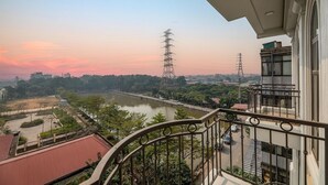 Un balcon donnant sur une rivière, un pont et des bâtiments situés au loin.