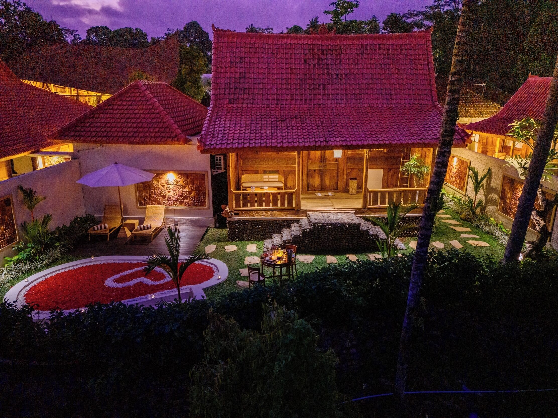 Une villa de style traditionnel, dotée d’un toit en tuiles, d’un jardin bien entretenu et d’un espace détente avec une table et des chaises.