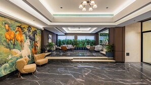 A spacious lobby with a marble floor, a mural of horses, and a seating area with modern chairs. - Effotel By Sayaji Sangli (Miraj)