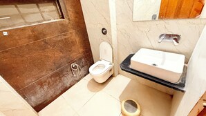 A bathroom with a toilet, sink, and shower area. - Hotel P & L near Mahakaleshwar Temple  (Ujjain)