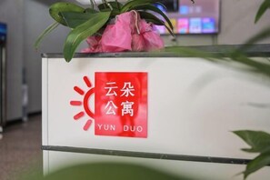 A reception desk with a sign that reads "YUN DUO" in both Chinese and English. - Yunduo Apartment (Foshan Zumiao Zhangye Culture Square) (Foshan)