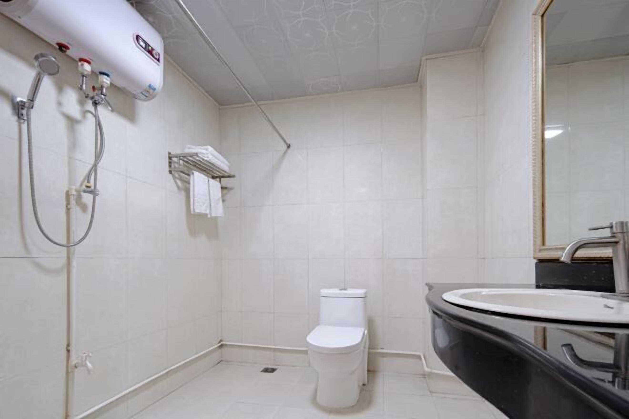 A bathroom with a toilet, a sink, and a shower unit.