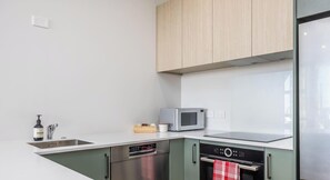 Eine moderne Küche mit Mikrowelle, Backofen und Geschirrspüler.