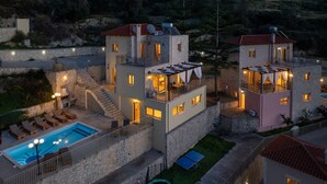 Un edificio de dos pisos con piscina, asientos al aire libre y una escalera.