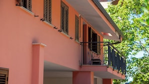 A pink building with multiple windows and a balcony.