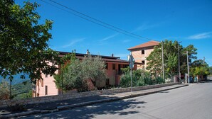 A building with a red roof, a stone wall, and a clear blue sky.