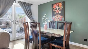 A dining area with a table, chairs, and a vase of flowers. - CircleWay Homes - Colwick (Colwick)