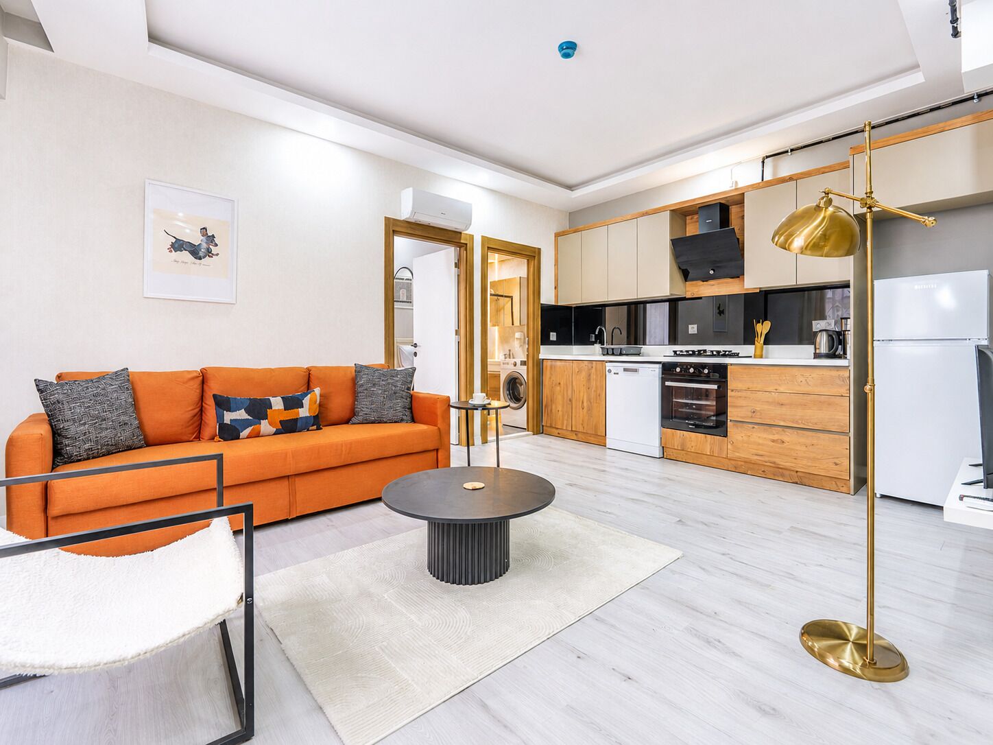 A modern apartment with a living area, kitchen, and a dining area.