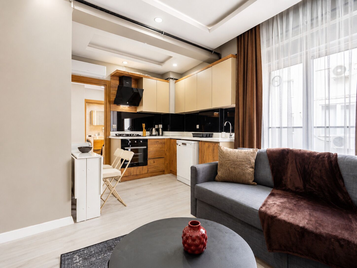 A modern living room with a sofa, a coffee table, and a kitchen in the background.