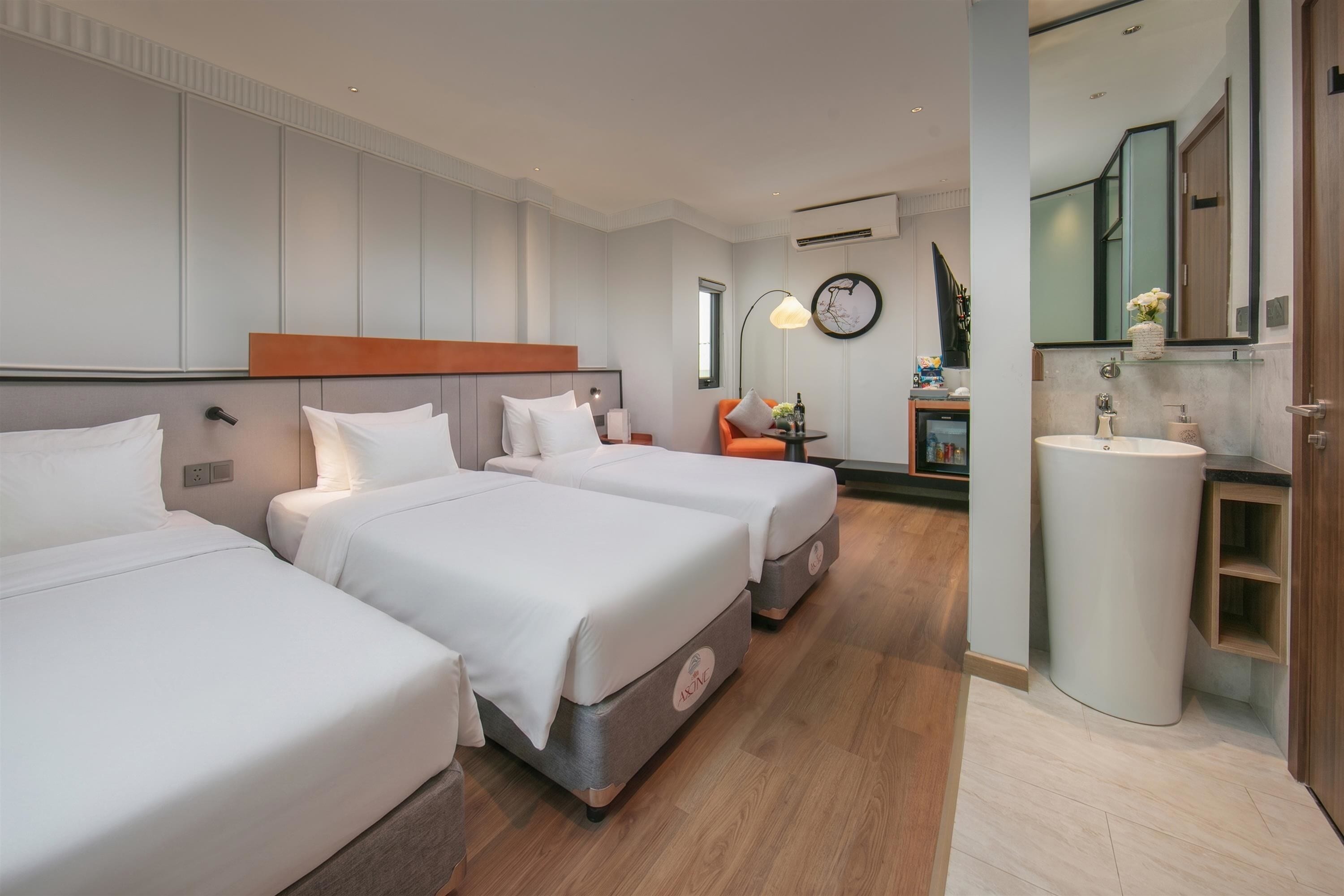 Une chambre d’hôtel avec deux lits, une salle de bain et un petit coin salon.
