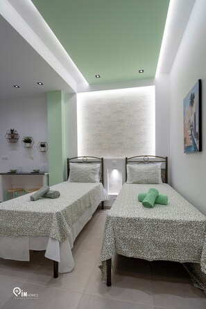 A bedroom with two single beds, a desk, and a window with a view. - The Mint - Stylish Studio in Egaleo/Athens (Egaleo)