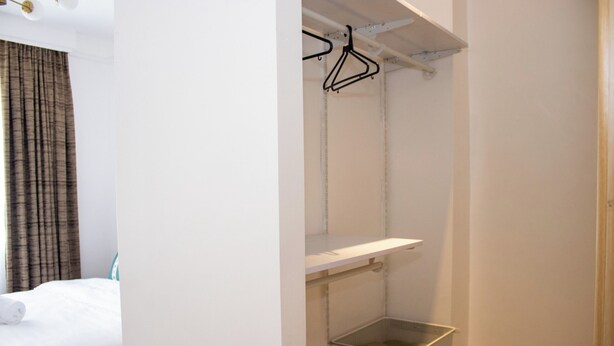 Ein Hotelzimmer mit Bett, Kleiderschrank und Ablagefläche.
