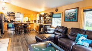 A compact living space with a kitchenette, a leather sofa, and a coffee table. - Perfect 3-bedroom house in Hope for a relaxing getaway (Hope)