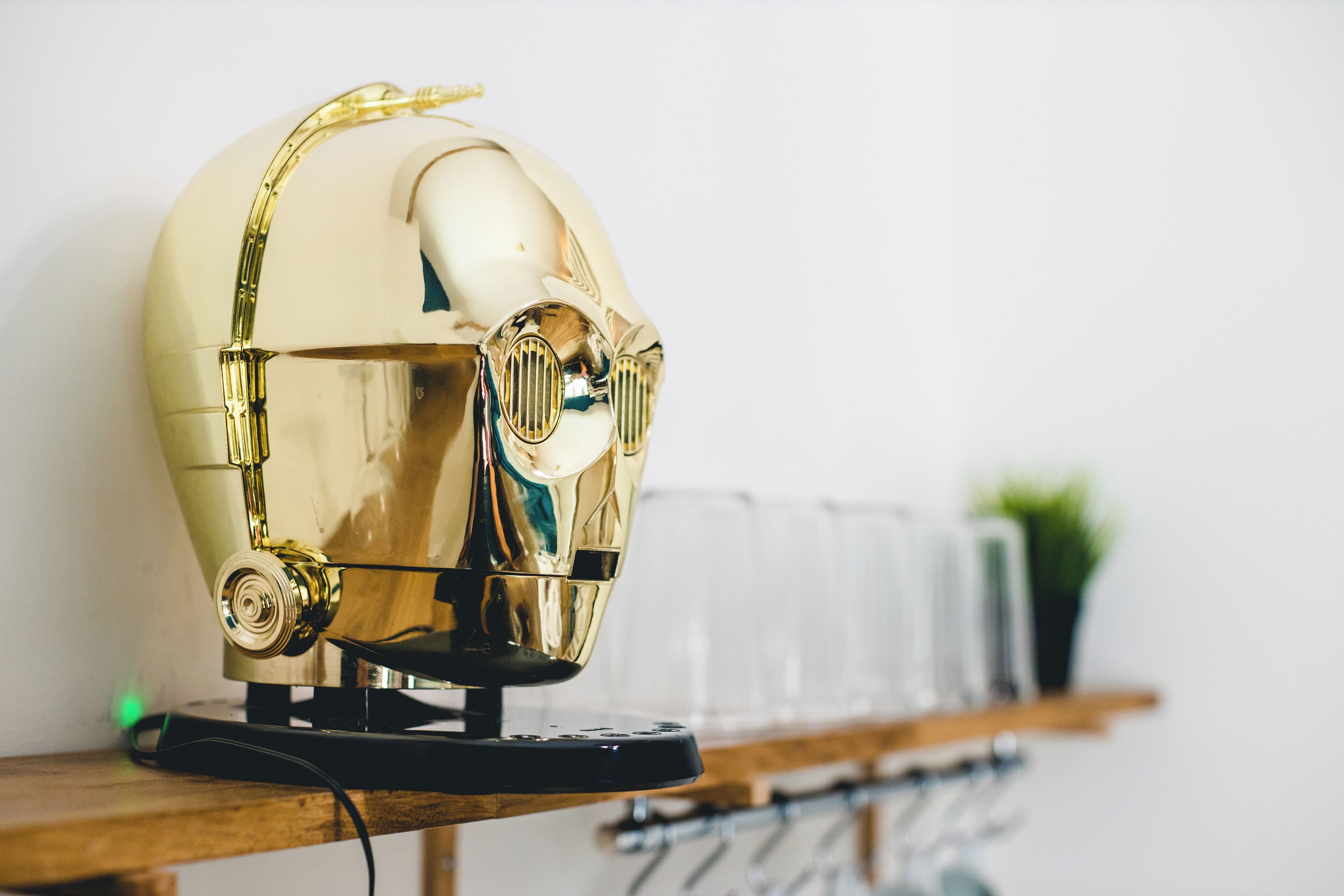 Ein goldfarbenes, reflektierendes Objekt, das einem Helm ähnelt, auf einer Holzfläche.