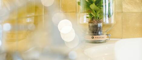 A bathroom with a glass terrarium containing a plant.