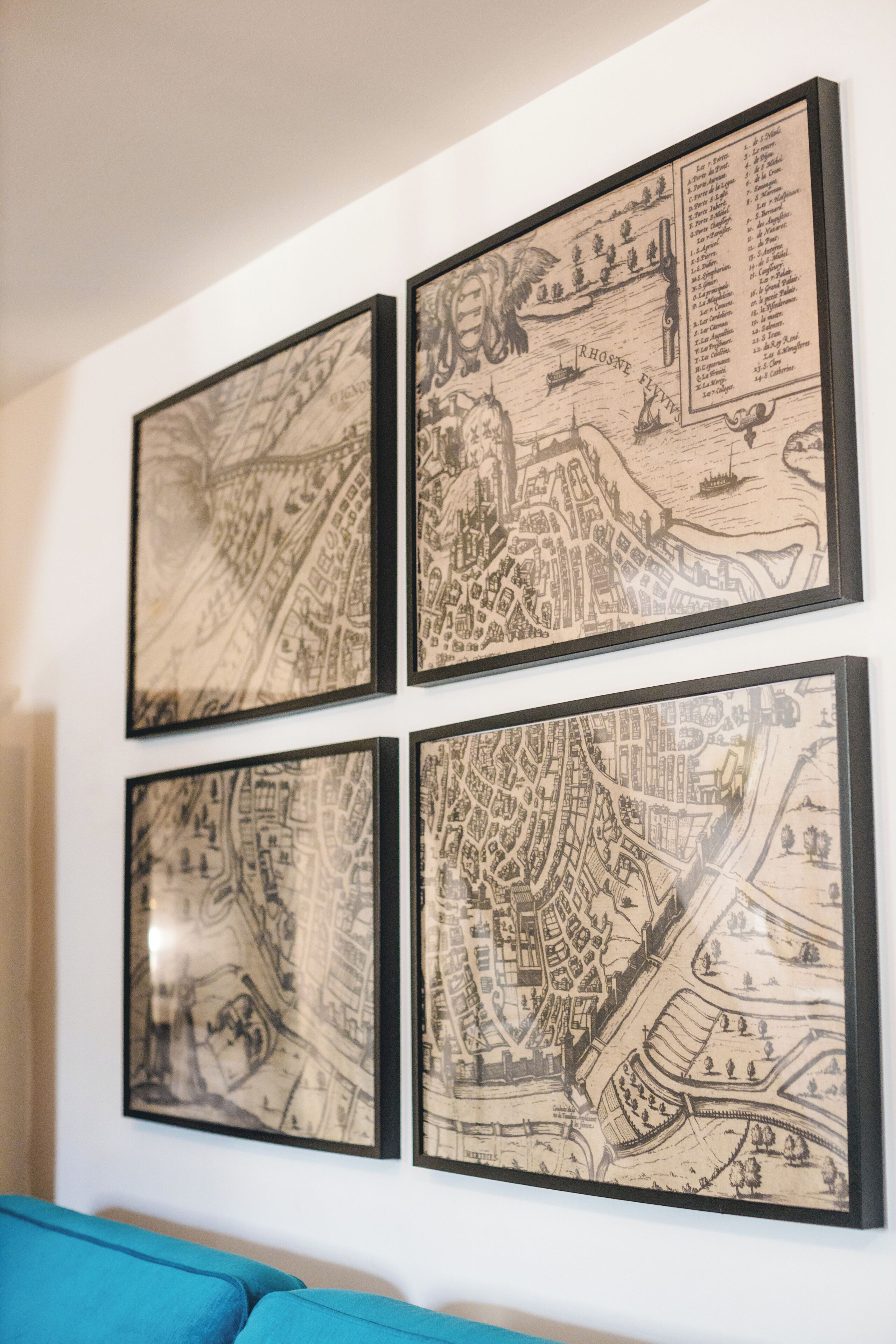 Four framed historical maps on a wall.