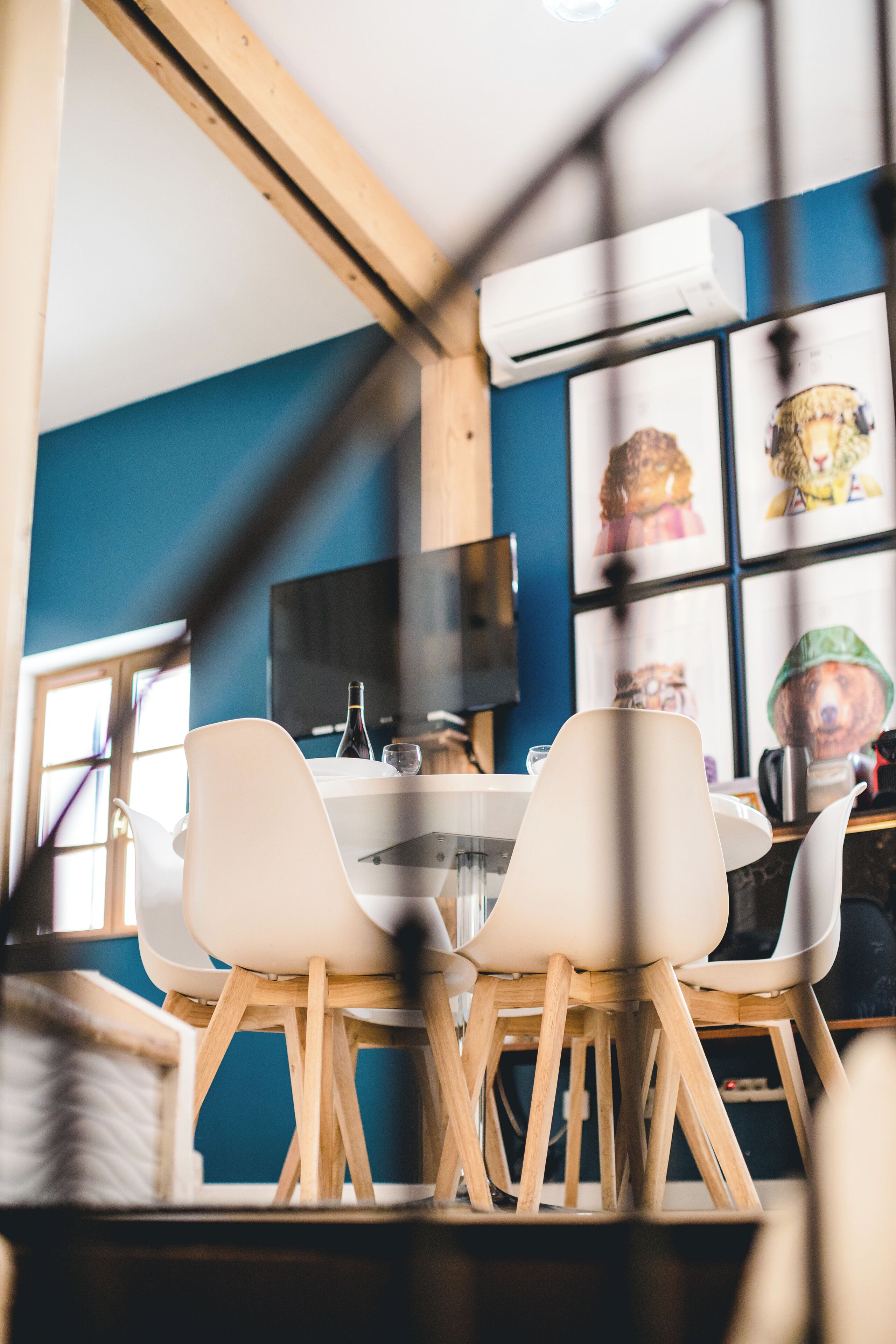 A dining area with a table and chairs, an air conditioning unit, and wall decorations.