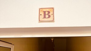 Un couloir avec une porte au fond et un panneau mural sur lequel figure un grand « B ».