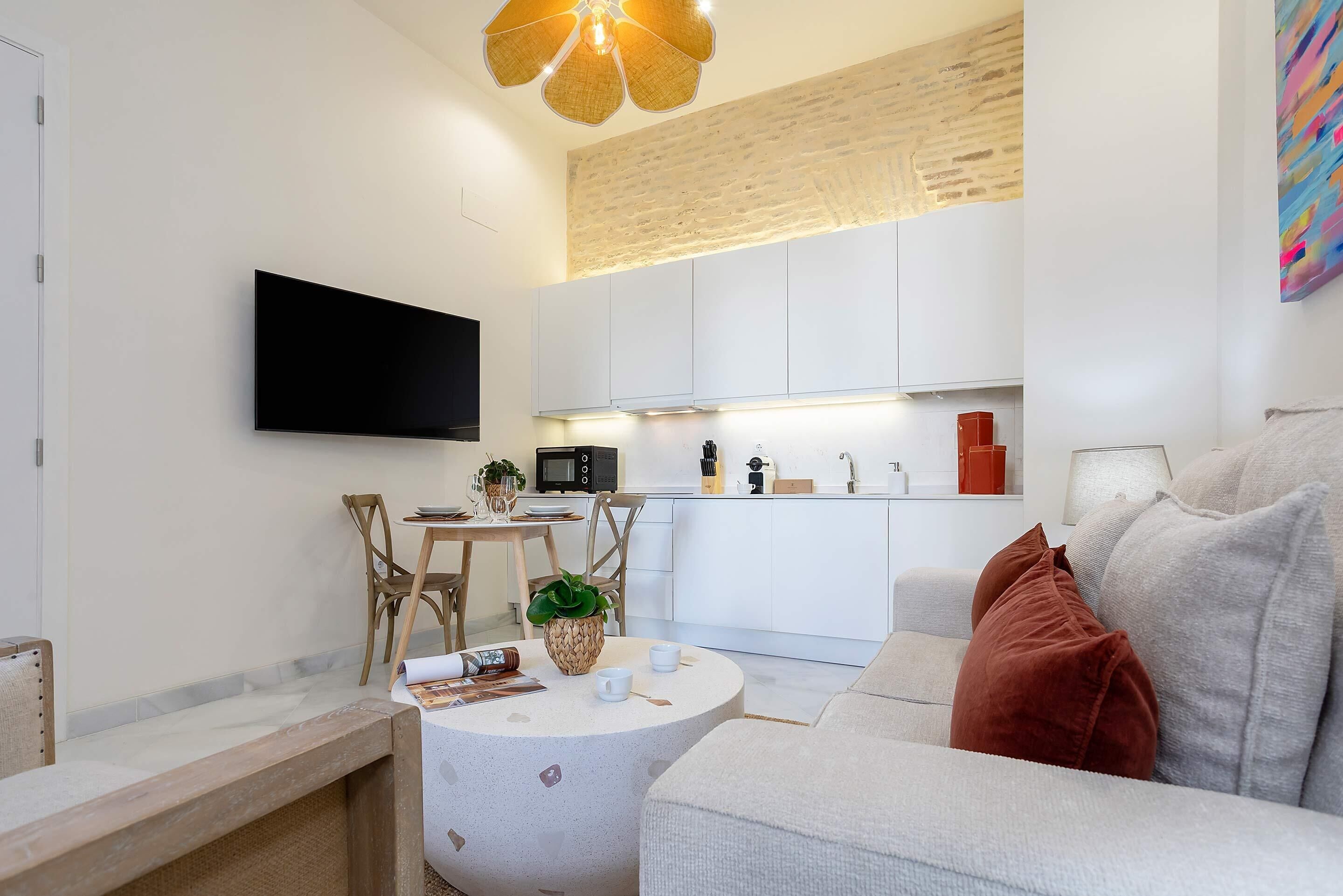 Una sala moderna con un sofá, una mesita de centro y un comedor con sillas y una mesa.