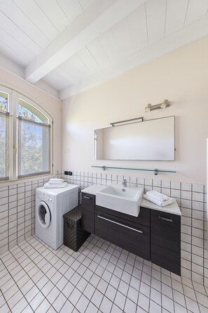 A modern bathroom with a washing machine, a sink, and a mirror. - 2 Bedroom apartment in resort with pools (Manerba del Garda)