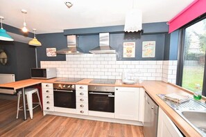 A compact kitchen with a microwave, stove, oven, and a sink. - Budget 5BR Apartment in the Heart of Headingley (Headingley)