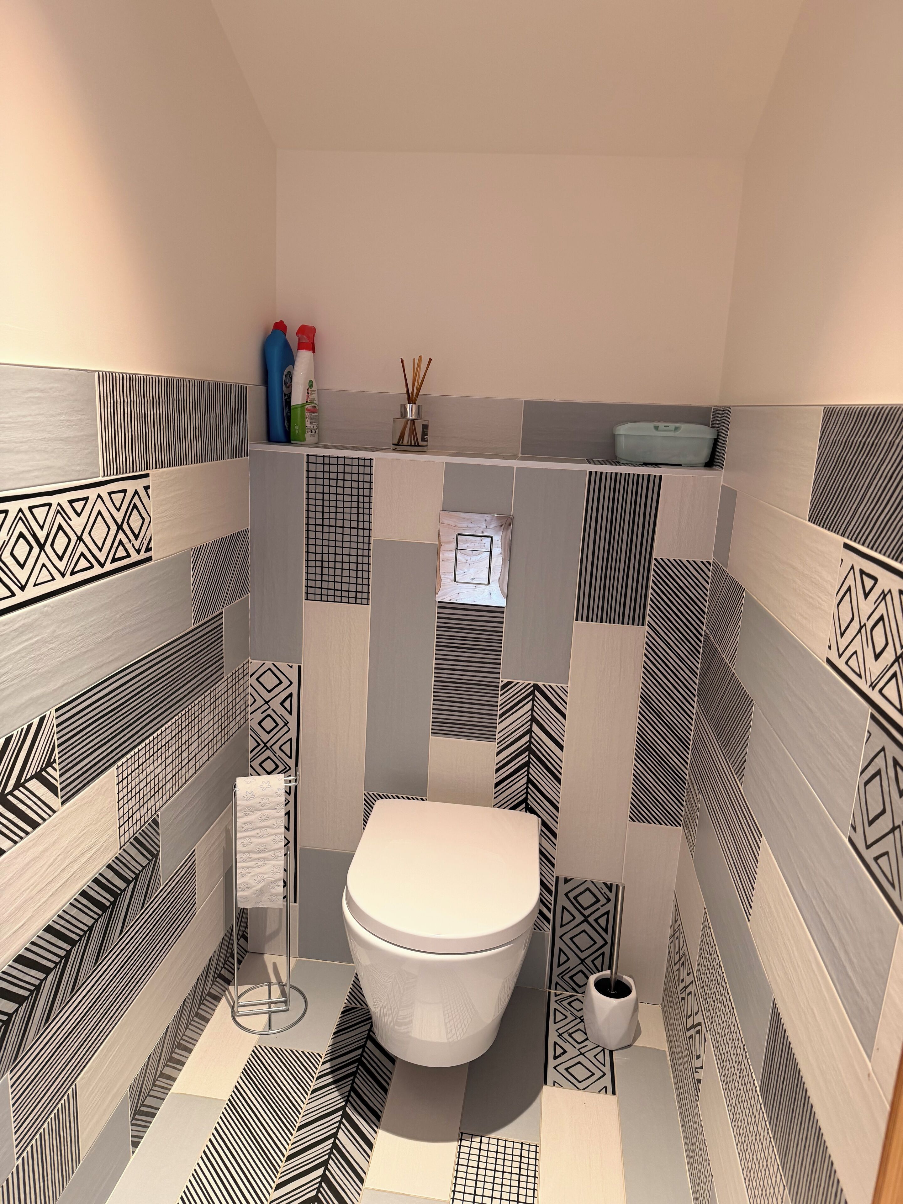 Un bagno dal design moderno, con il water, un lavandino e uno specchio.