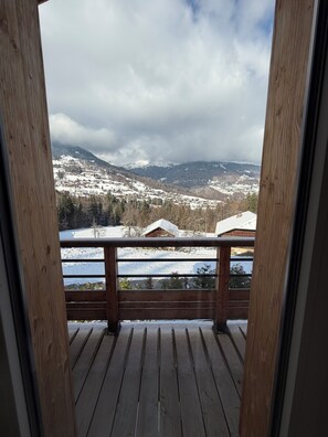 A wooden deck with a view of a snowy mountain landscape. - Mountain chalet overlooking Cordon near Combloux, Megeve and Chamonix (Sallanches)