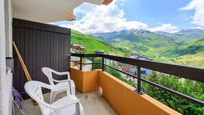 Ein Balkon mit Blick auf grüne Hügel und Berge.