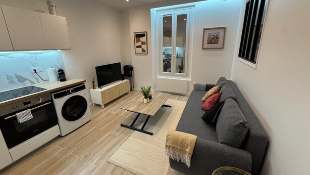 A modern apartment with a kitchen, a living area, and a view of the outside. - 2-room apartment, new/fully renovated, sleeps 4 (Montrouge)