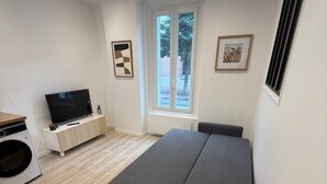 A modern bedroom with a bed, a TV, and a washing machine. - 2-room apartment, new/fully renovated, sleeps 4 (Montrouge)
