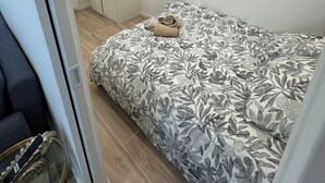 A bedroom with a bed, a wardrobe, and a mirror. - 2-room apartment, new/fully renovated, sleeps 4 (Montrouge)