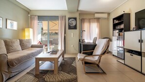 Ein modernes Wohnzimmer mit einer Couch, einem Couchtisch, einem Sessel und einem Bücherregal.