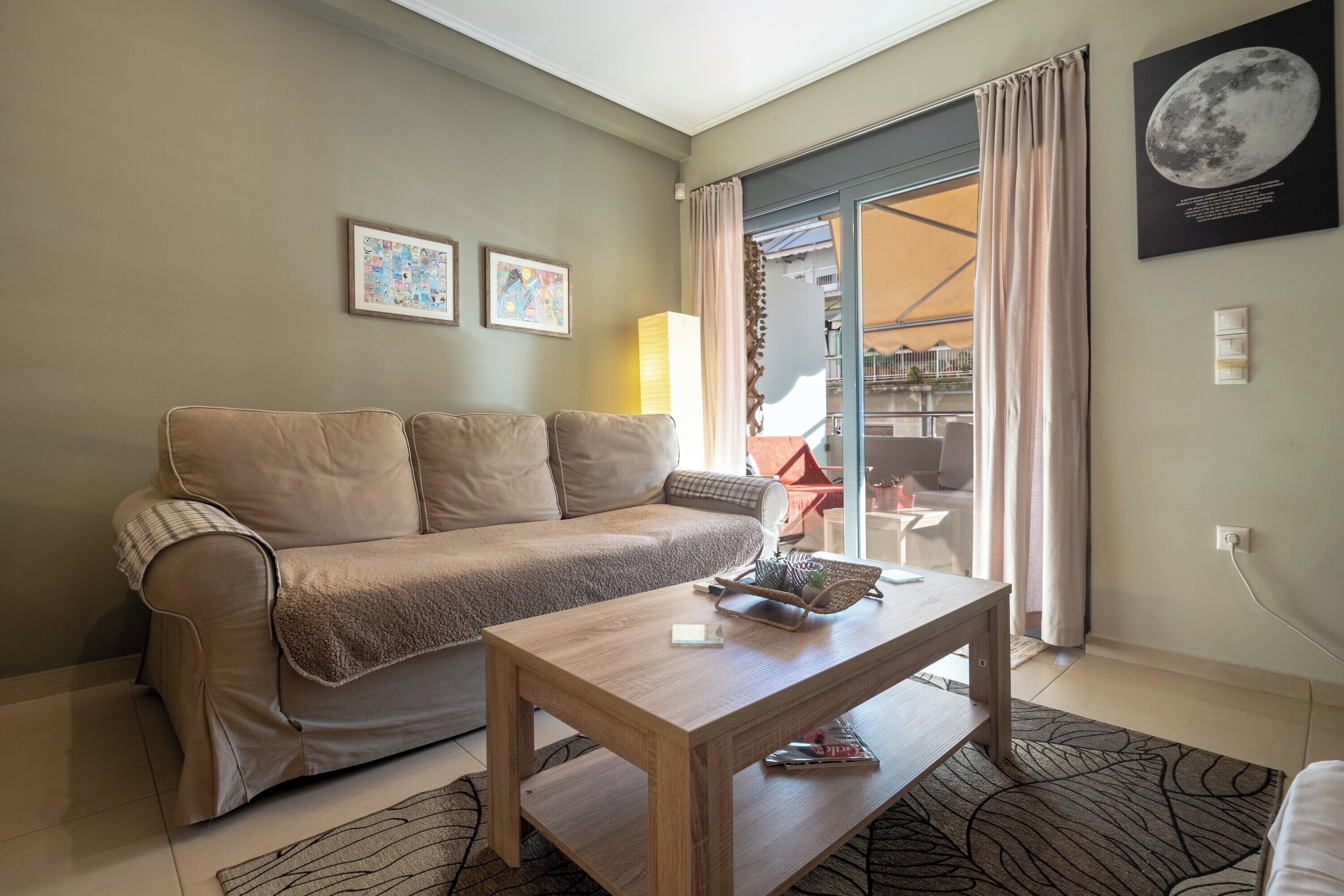 Ein Wohnzimmer mit einer Couch, einem Holztisch und einem gemusterten Teppich.