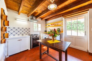 A kitchen with wooden beams, a white refrigerator, a stove, and a sink. - Gîte la Sarpette – Secluded Retreat in Nature (Sainte-Radegonde)