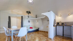 A compact living space with a dining area, kitchenette, and a small seating area with a sofa. - Cottage “Les Blaches” with shared pool, Wi-Fi, and air conditioning (Chauzon)
