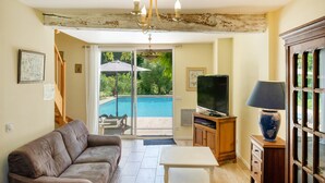A living room with a sofa, a coffee table, a TV, and a lamp. - Gite de la Barthe – near Dax (Garrey)