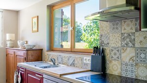 A kitchen with a window, a sink, a stove, and a dishwasher. - Gite de la Barthe – near Dax (Garrey)