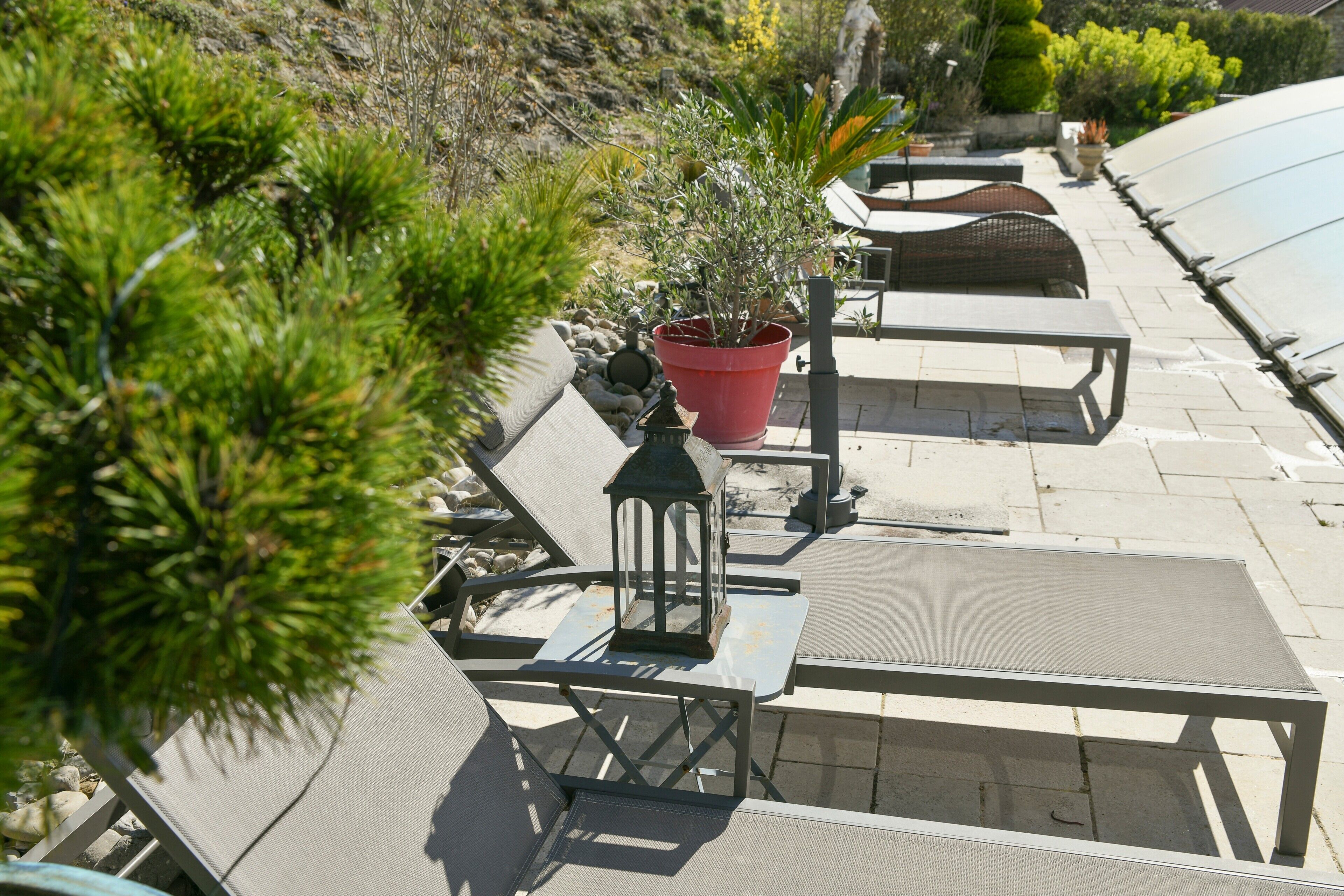 Outdoor seating with tables and chairs, a potted plant, and a lantern.
