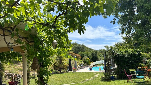 A garden with a pool, outdoor seating, and a pergola. - Bed and Breakfast 'Maison D'hotes Dolce Vita' with Mountain View, Shared Pool and Wi-Fi (Veyssilieu)