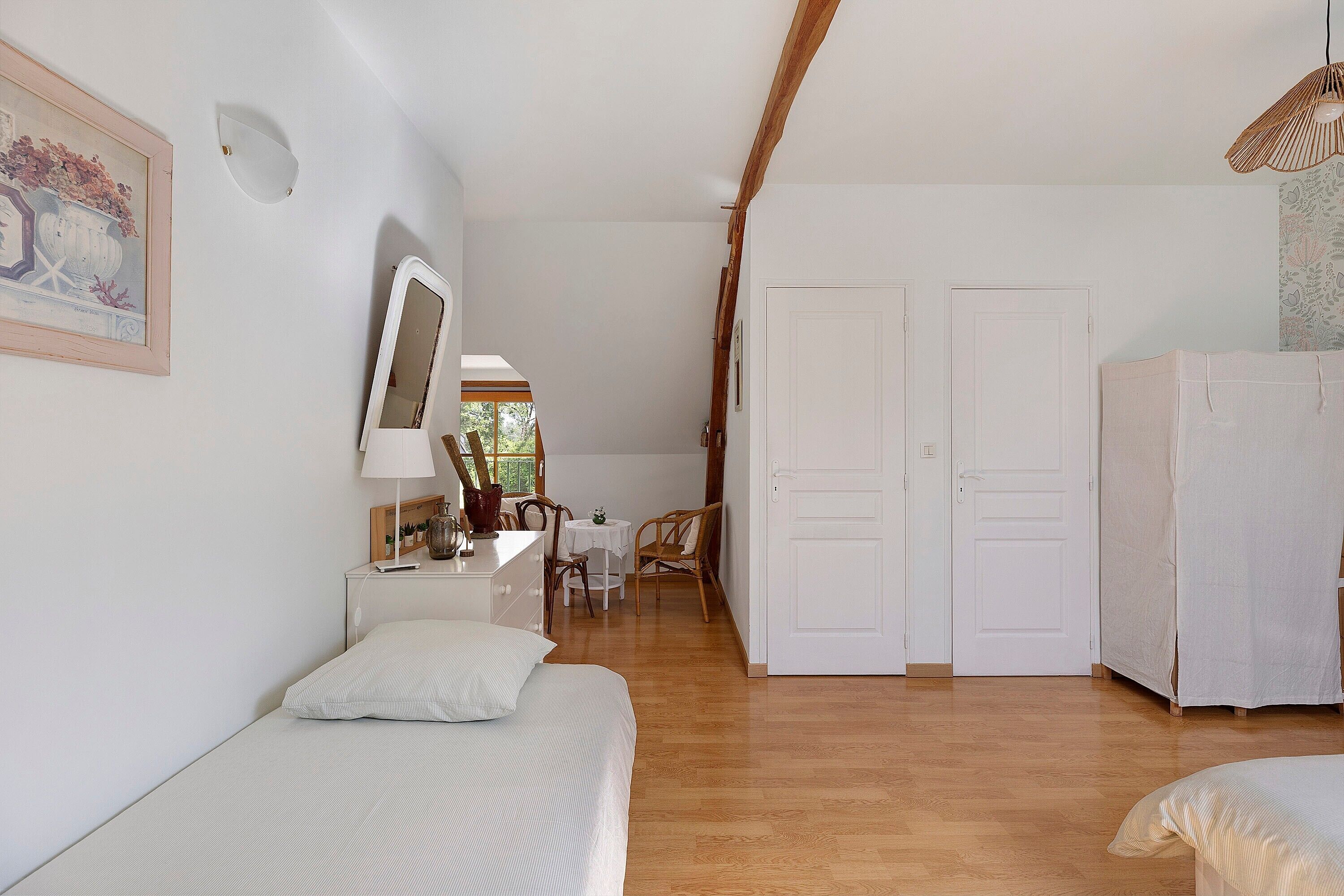 Une chambre à coucher comprenant un lit, un bureau, une chaise et une armoire.