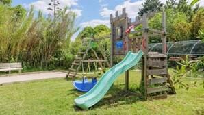 A playground with a slide, swings, and a climbing structure. - Gîte "Les Combes" with Shared Pool, Wi-Fi, and Air Conditioning (Chauzon)